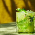 Mocktail with cucumbers and basil, chili salt and edible blossoms