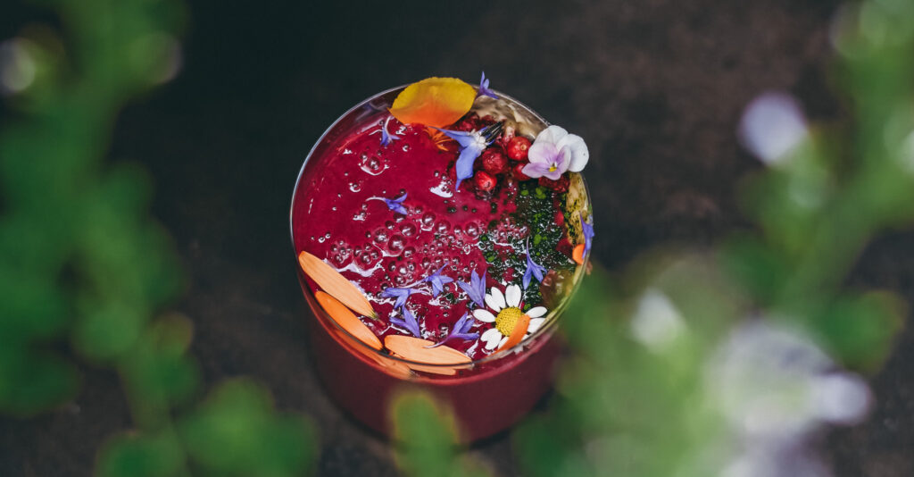 Summer Smoothie with cherries and edible blossoms, landscape view