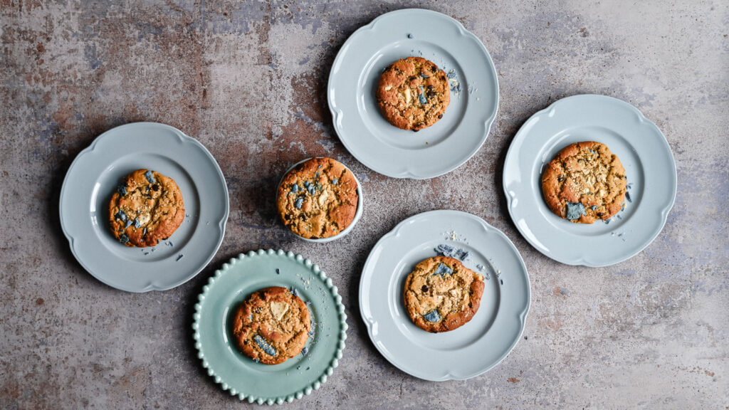 Tahini cookies with blue spirulina chocolate on blue plates