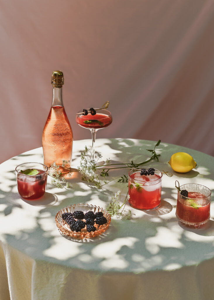 Table in with light shadow, rosé prosecco and blackberry mocktails