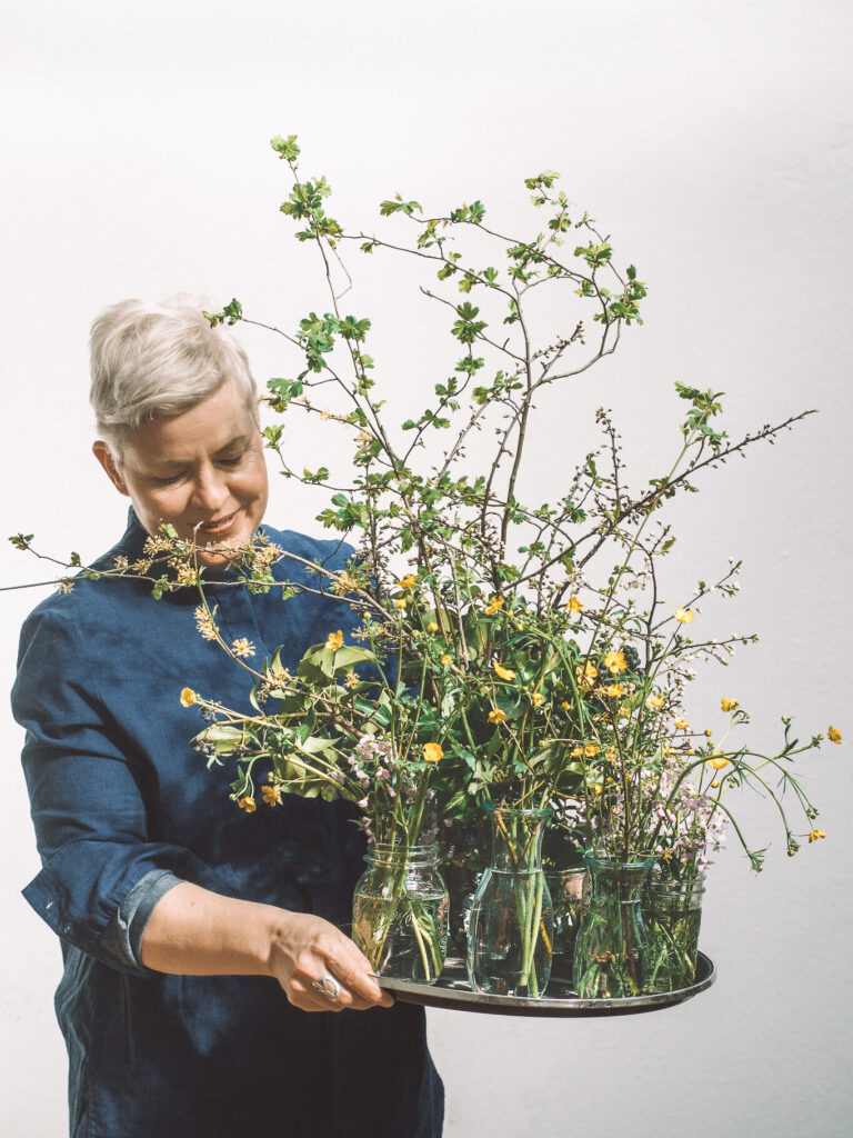 Heike Müller, photographer holding plate with flowers