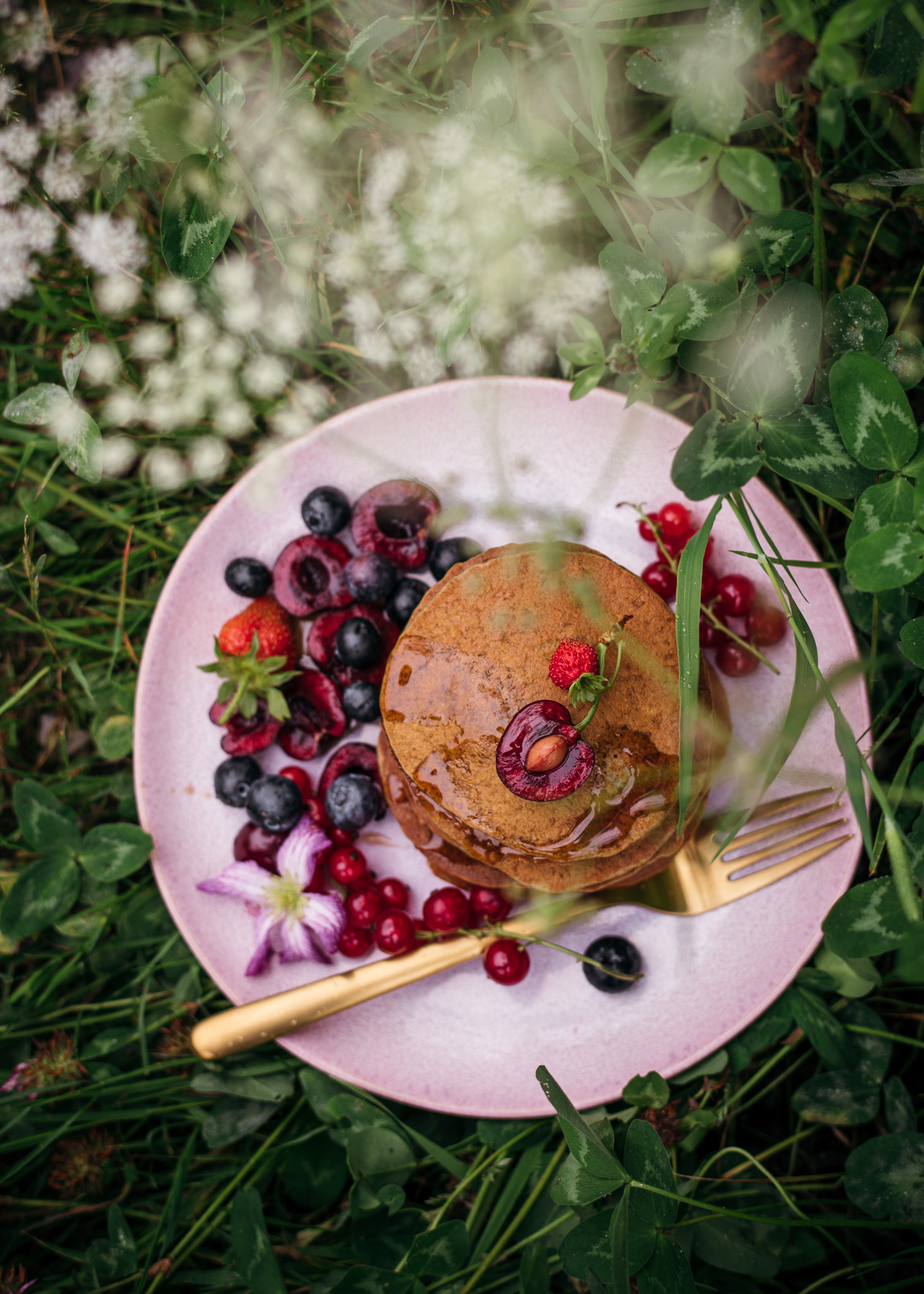 Pankcakes in th field with berries and cherries