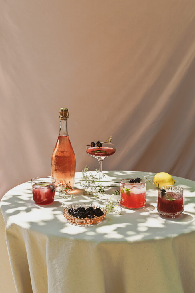 Blackberry Lemon balm Mocktails with booze free rosé Prosecco on a table in the sun