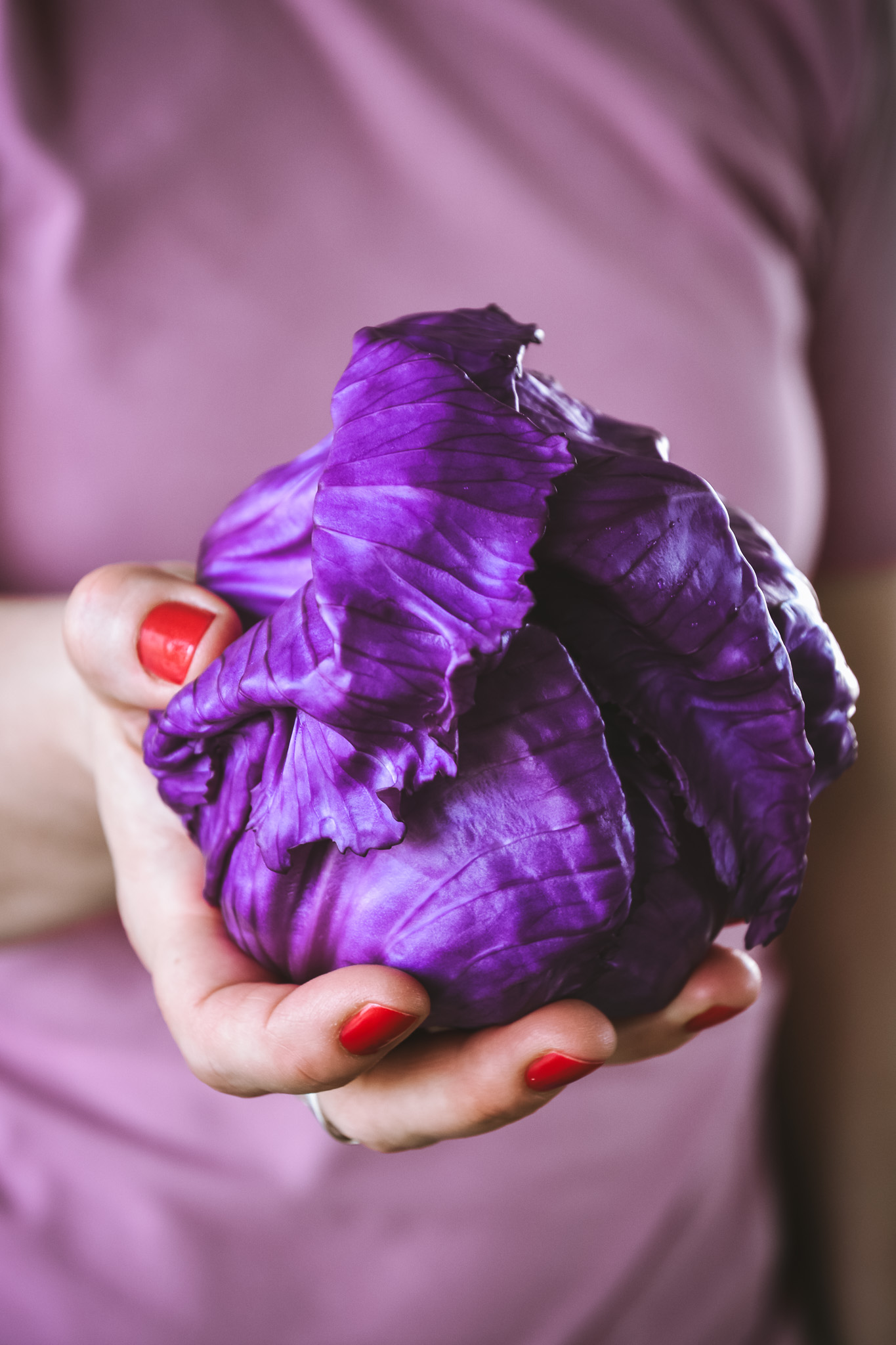 Purple cabbage hold in hand with red nail polish