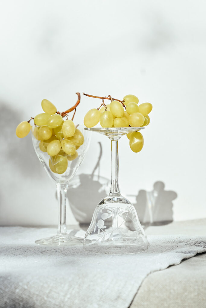 Vintage glasses with yellow grapes in sunlight